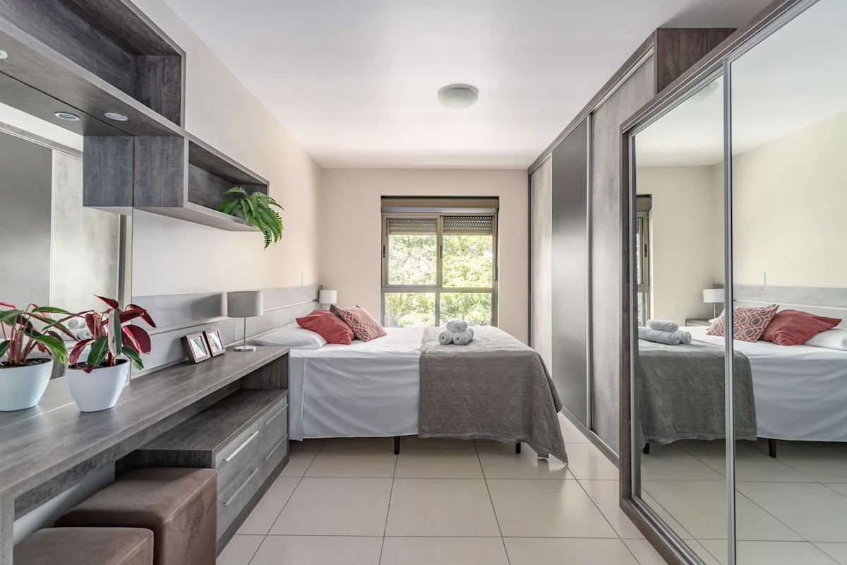Quarto 1 com cama queen e armários espelhados